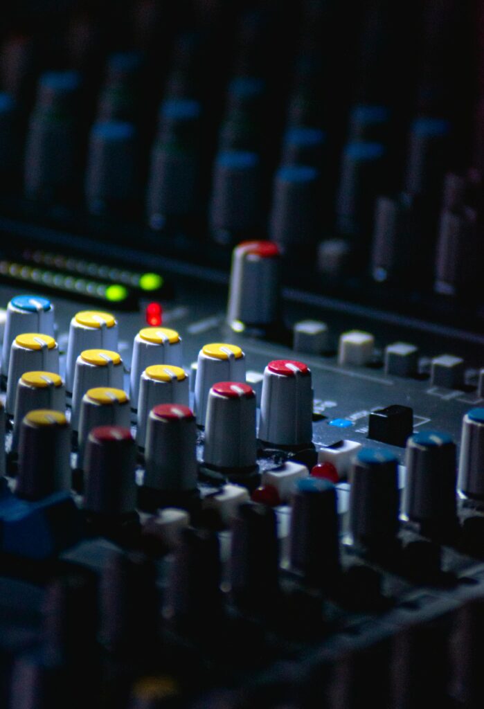 pexels-photo-6707294-6707294 Colorful knobs on an audio mixer in a moody, dimly lit setup. Ideal for sound production themes.
